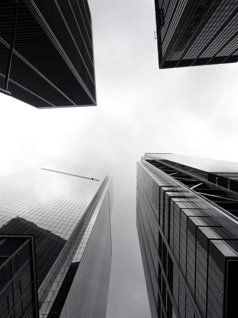 Black and white low angle view of modern skyscrapers in New York City showcasing architectural design.